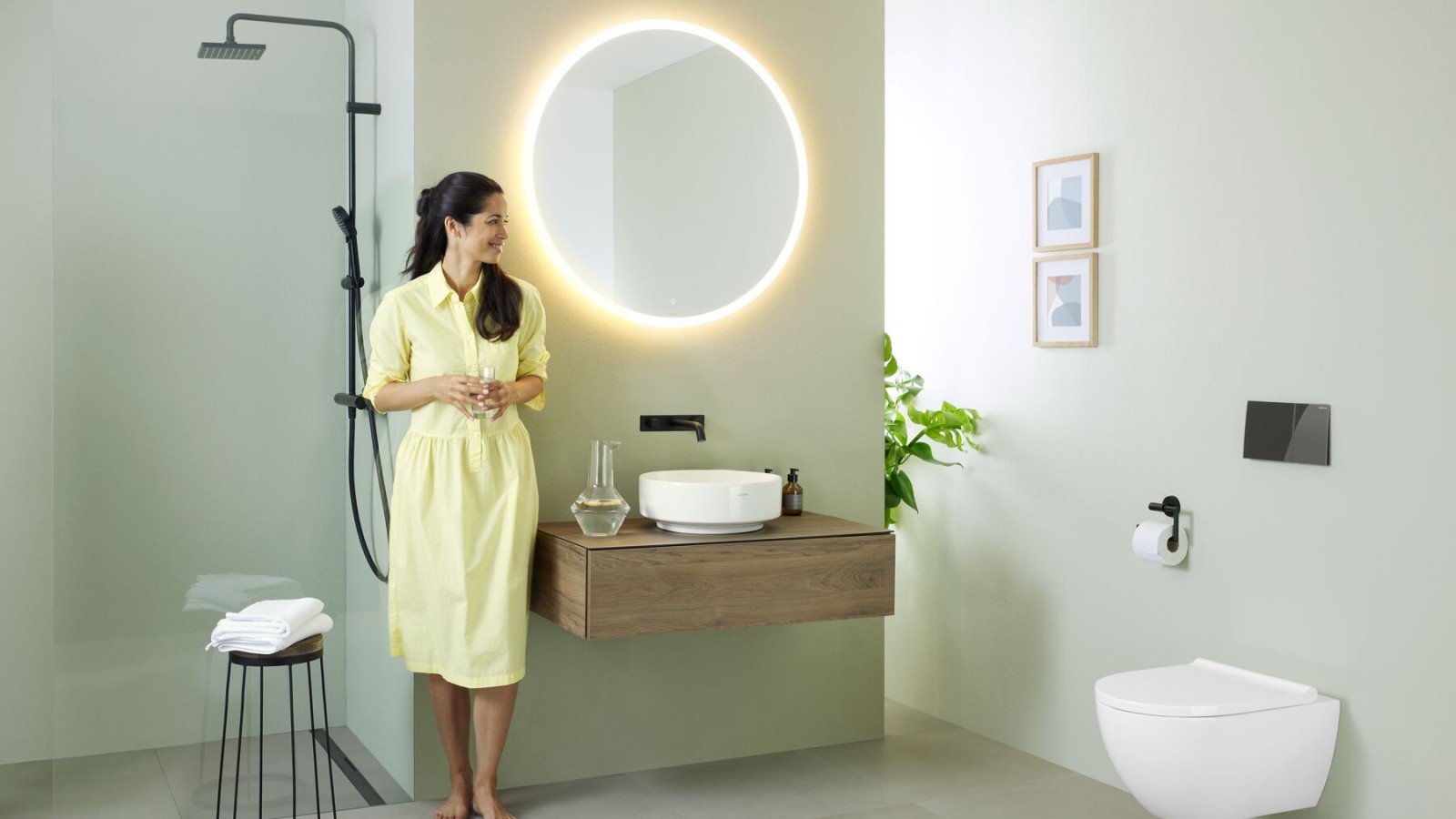 在配备 Geberit Option 镜柜和 Geberit VariForm 维纷洗脸盆的浴室中的女士 在配备 Geberit Option 镜柜和 Geberit VariForm 维纷洗脸盆的浴室中的女士