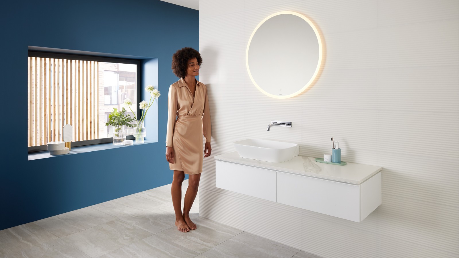 Woman leaning against the wall in the bathroom with Geberit products from the Mix & Match range Woman leaning against the wall in the bathroom with Geberit products from the Mix & Match range