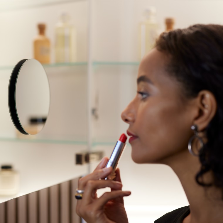 对着浴室镜化妆的女士 对着浴室镜化妆的女士