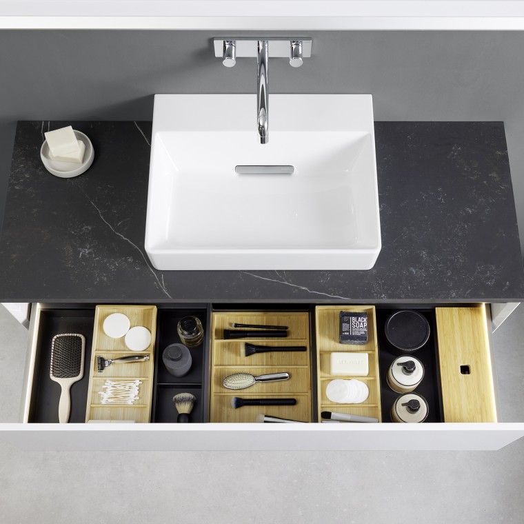 View from above into an open Geberit ONE washbasin drawer with organiser boxes View from above into an open Geberit ONE washbasin drawer with organiser boxes