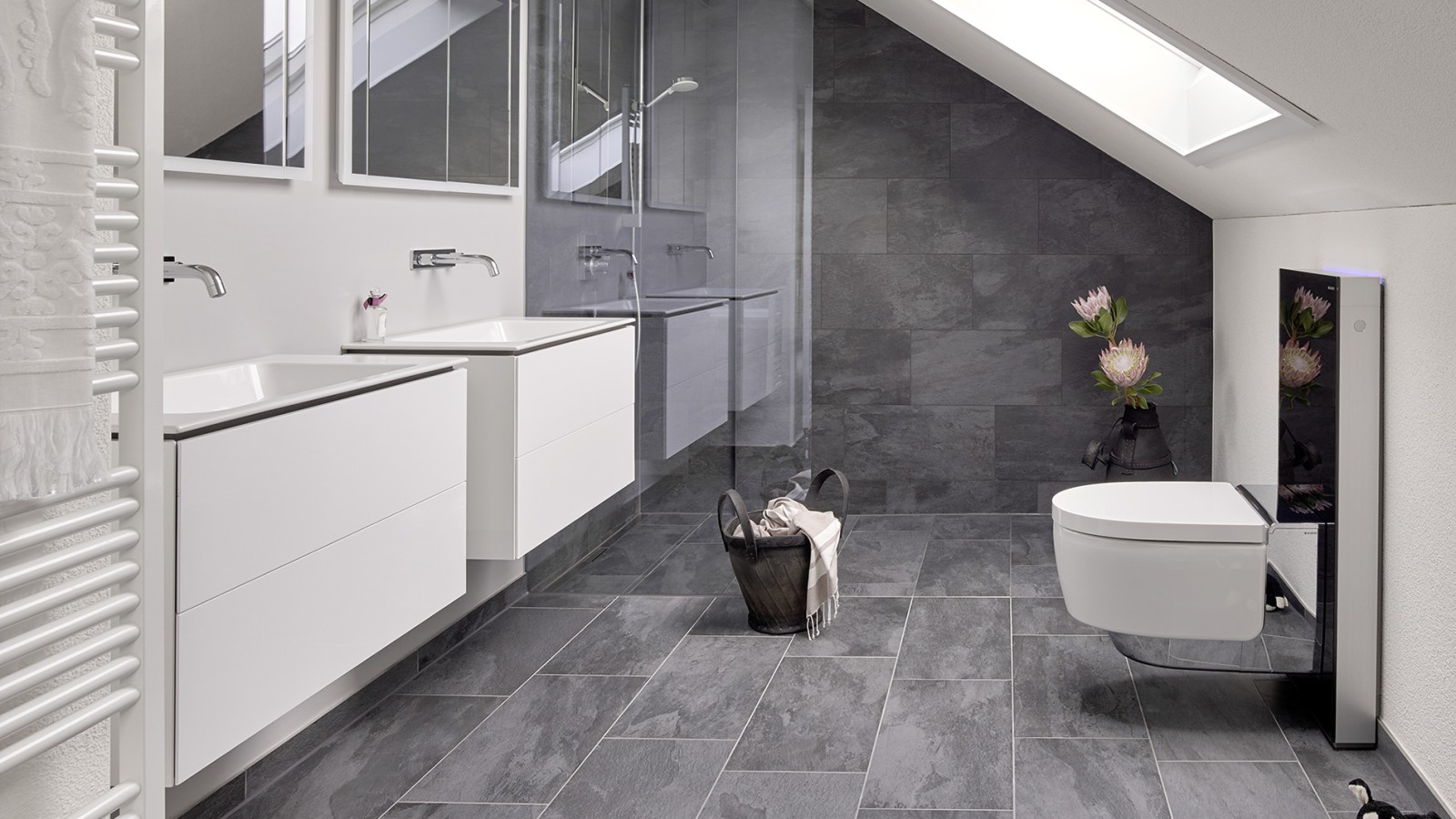 有斜屋顶的浴室，配备 Geberit ONE 卫浴系列产品以及 Geberit AquaClean 和 Monolith 智能座便器
