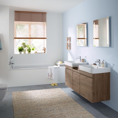 以浅蓝色墙面搭配吉博力山核桃木卫浴家具、镜柜、冲水面板和陶瓷器具的家庭卫浴空间